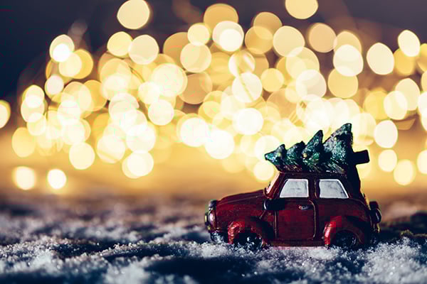 red-car-with-a-christmas-tree-driving-through-K97SRMX-1